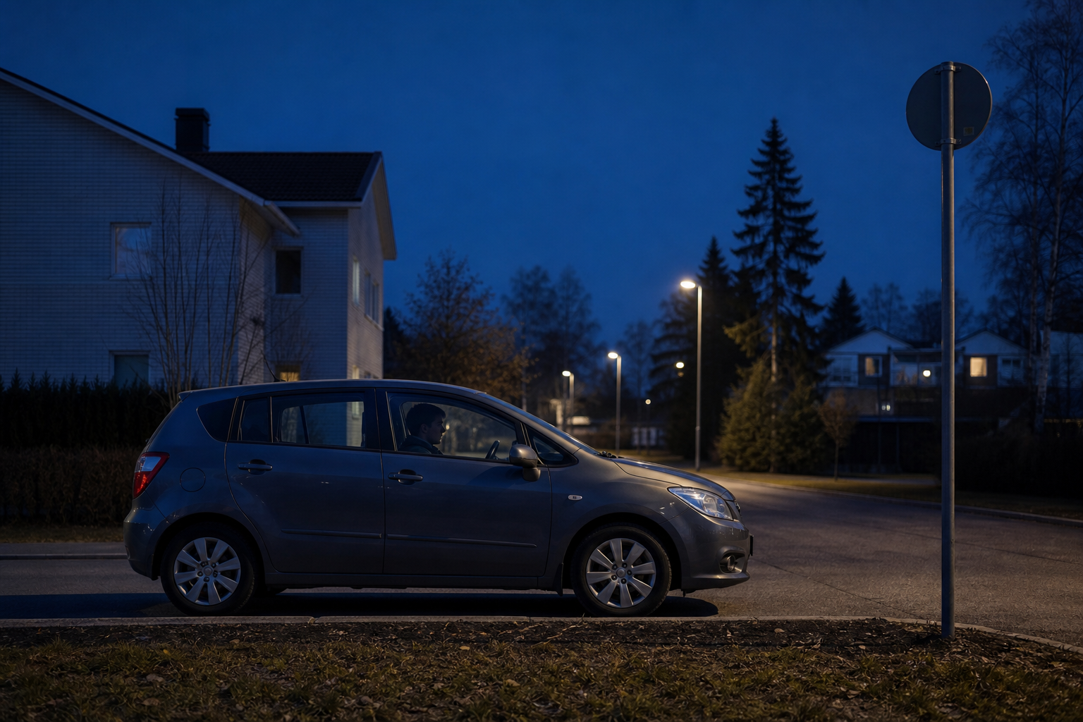 Yöllinen katu ja pysäköity henkilöauto symboloivat alaikäisten ajo-oikeuden yöaikarajoitusta.